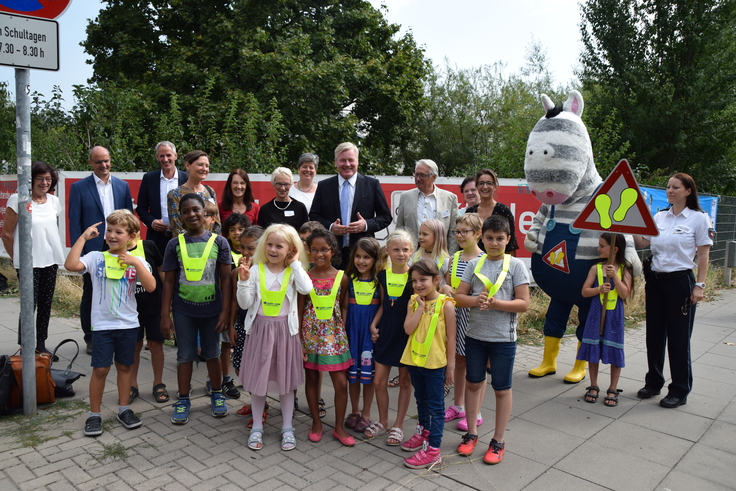 Verkehrsminister Dr. Bernd Althusmann gemeinsam mit Vertretern der Kooperationspartner und einer Schulklasse der Albert-Schweitzer-Schule vor der "Elternhaltestelle"