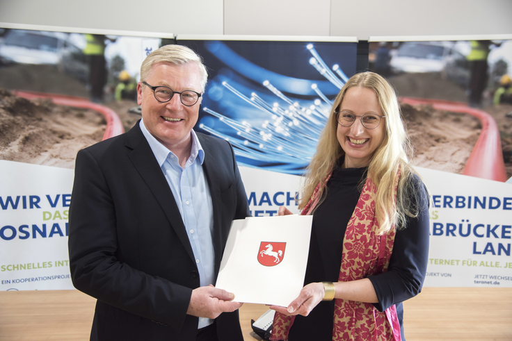 Wirtschaftsminister Althusmann (links) überreicht Landrätin Anne Kebschull eine Mappe mit Niedersachsen-Logo